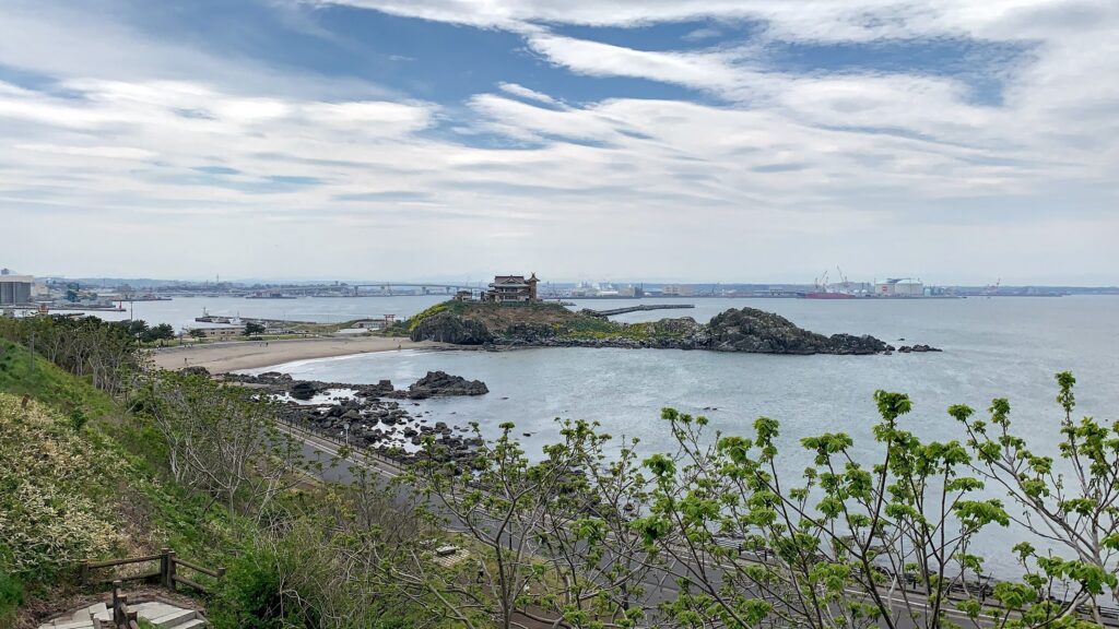 A scenic shot of the Umineko line with the Kabushima Shrine and the ocean in the backdrop.