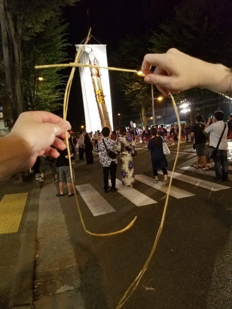 Japan's largest straw sandal framed by a souvenir piece of straw. Photo: Edward Portillo