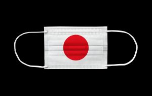 Flag of Japan on a disposable surgical mask. White background isolated